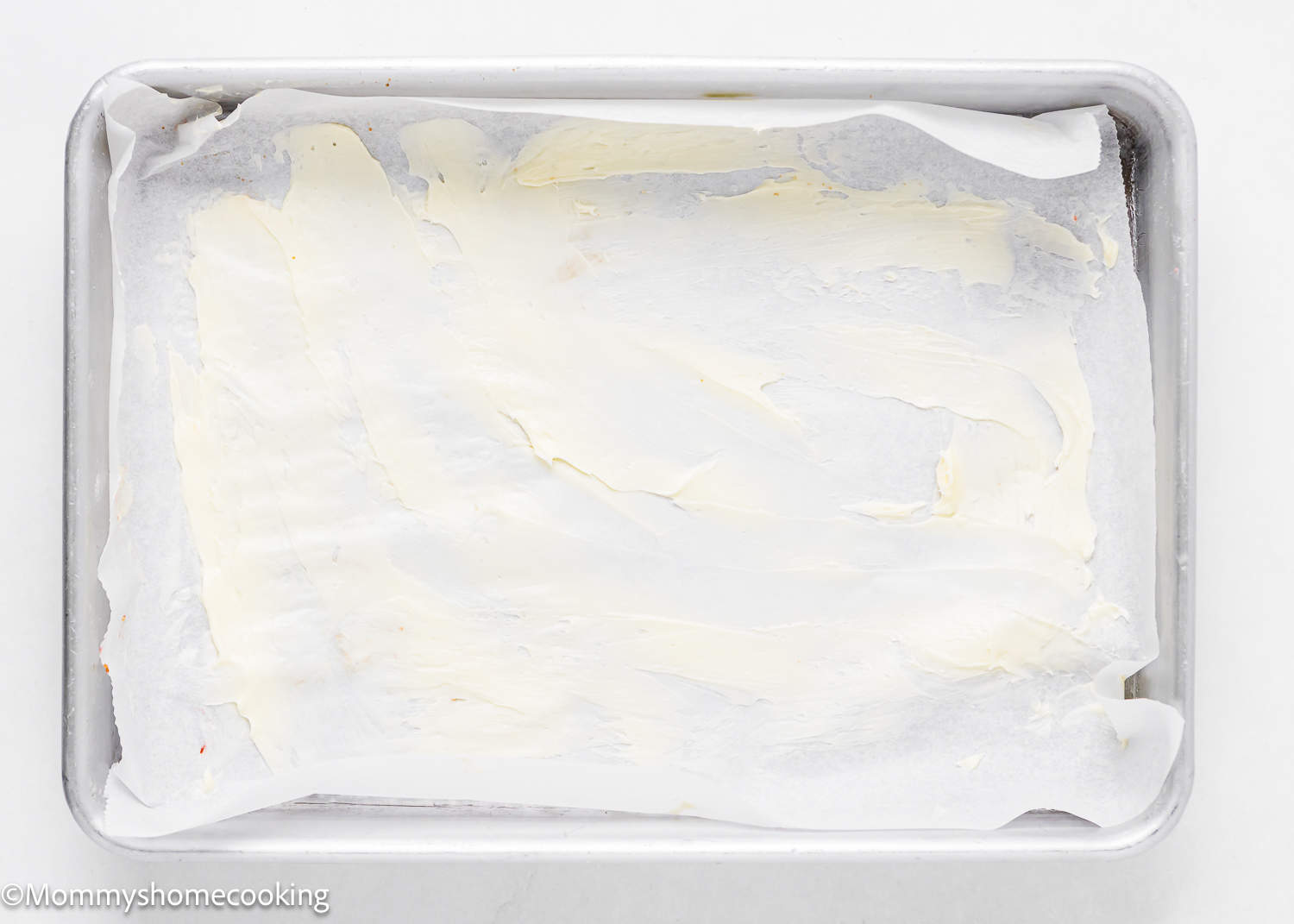 a baking pan for strawberry rolls lined with parchment paper and butter.