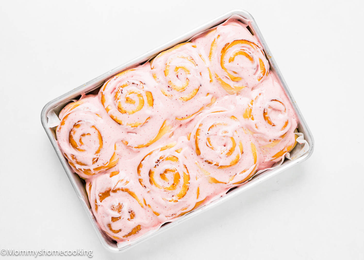 Strawberry Rolls with strawberry frosting in a baking tray.