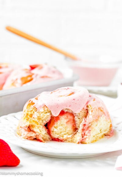 an Easy Strawberry Roll with strawberry frosting from on a plate showing its fluffy and tender texture.