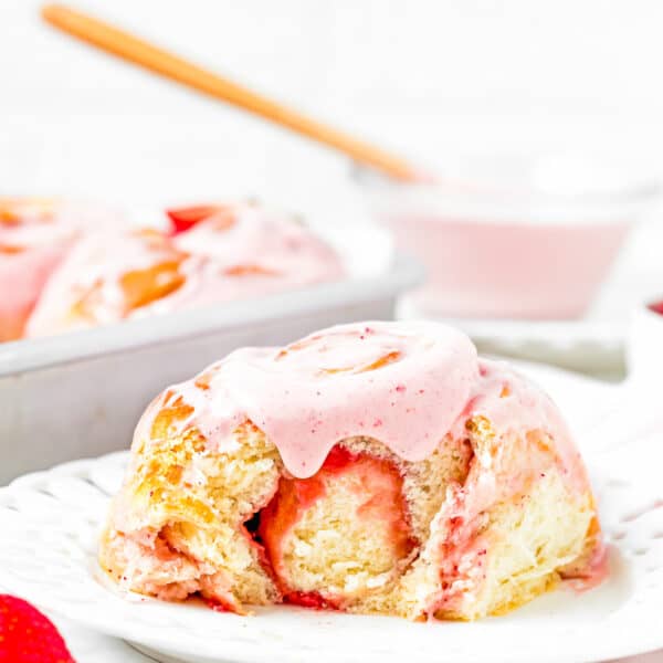 an Easy Strawberry Roll with strawberry frosting from on a plate showing its fluffy and tender texture.