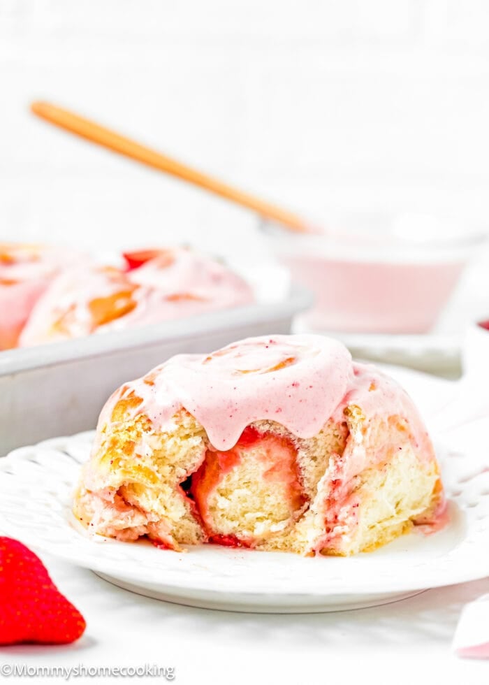 an Easy Strawberry Roll with strawberry frosting from on a plate showing its fluffy and tender texture.