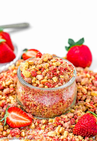 homemade Strawberry Crunch in a small glass bowl with fresh strawberry on the sides.