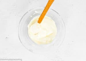 Cream Cheese Frosting For Cinnamon Rolls in a bowl with a spatula.
