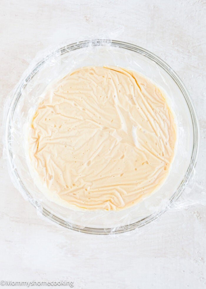 Vegan Pastry Cream in a bowl covered with plastic wrap.