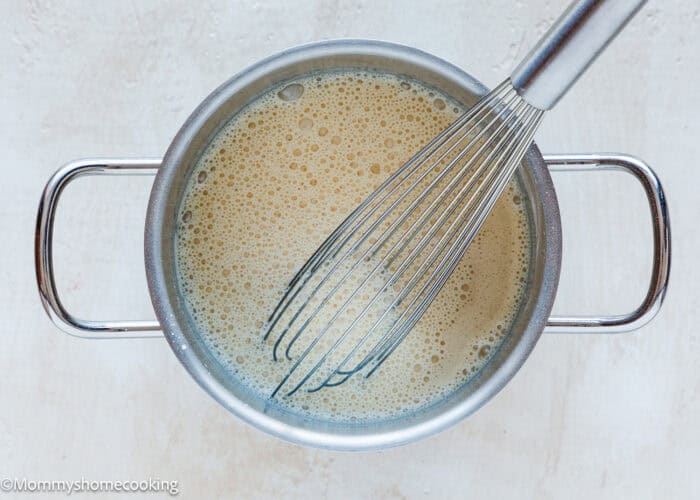 Vegan Pastry Cream being made in a pot with a whisk.