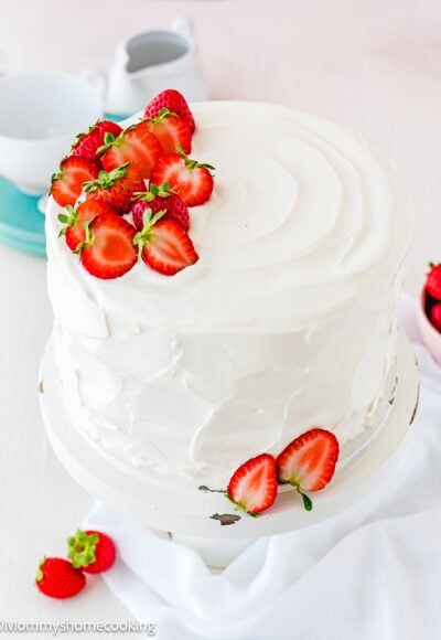 eggless strawberry shortcake cake decorated with Easy Whipped Cream Frosting and fresh strawberries.