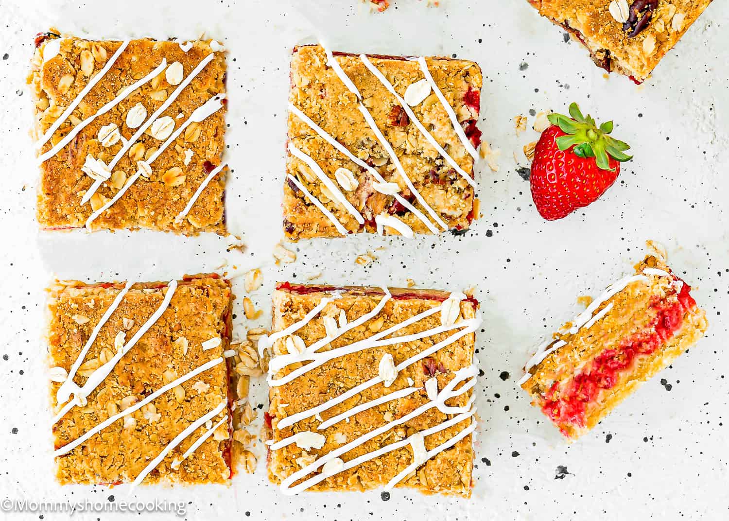Eggless Strawberry Bars over a white surface with fresh strawberries on the side.