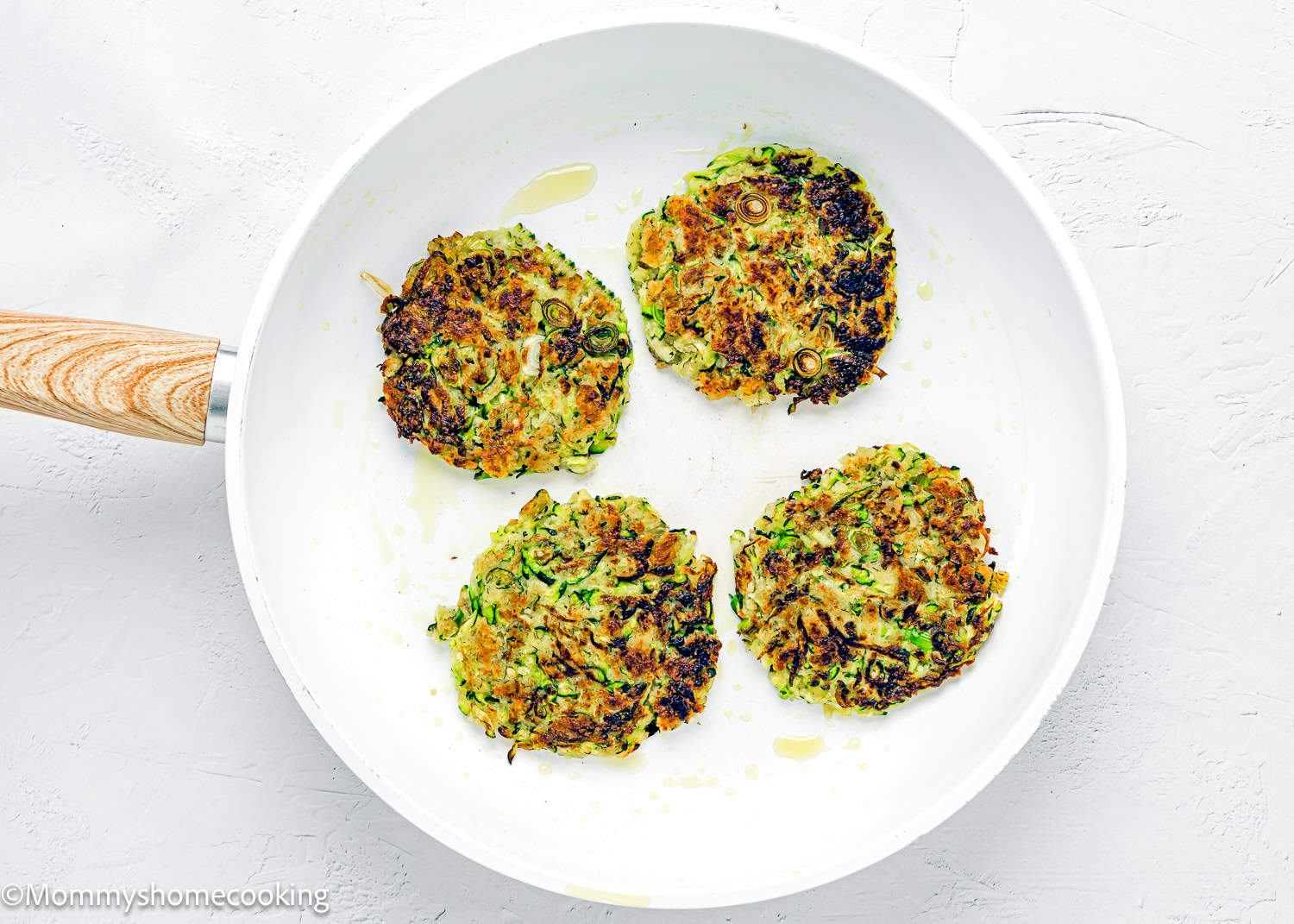 four Eggless Zucchini Fritters in a skillet.