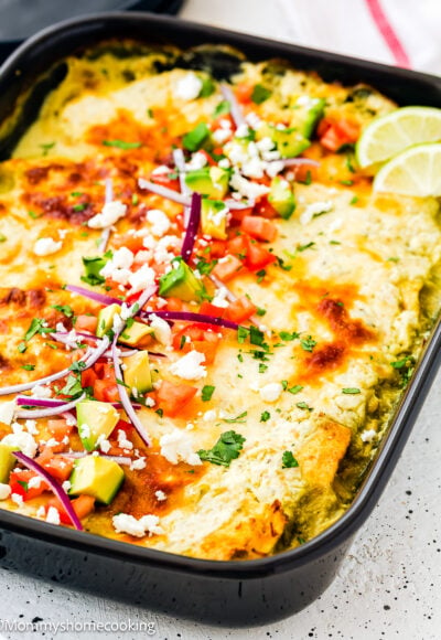 Super Easy Enchiladas Suizas with topping in a black casserole dish.