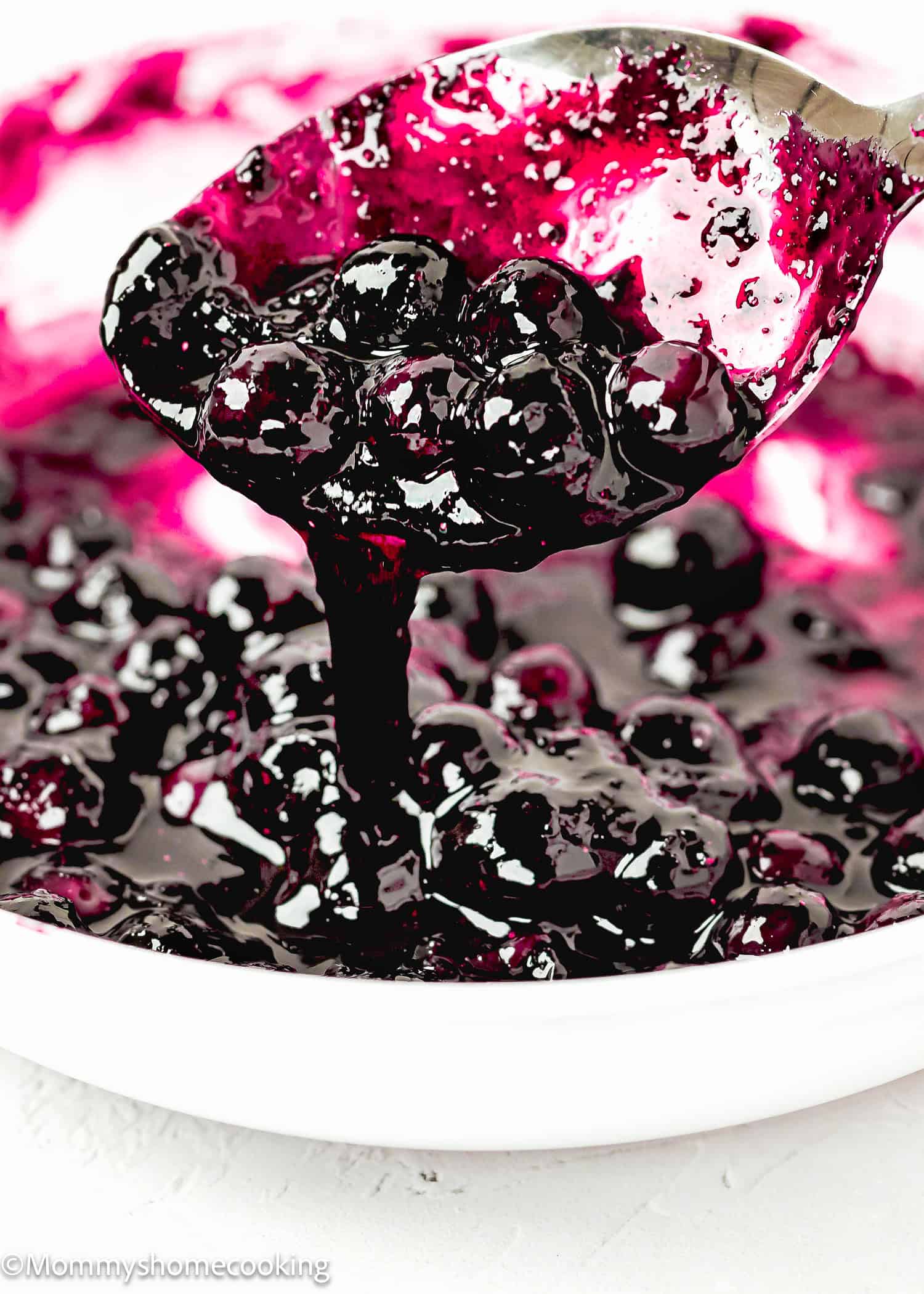 Quick and Easy Homemade Blueberry Sauce Topping in a saucepan with a spoon. 