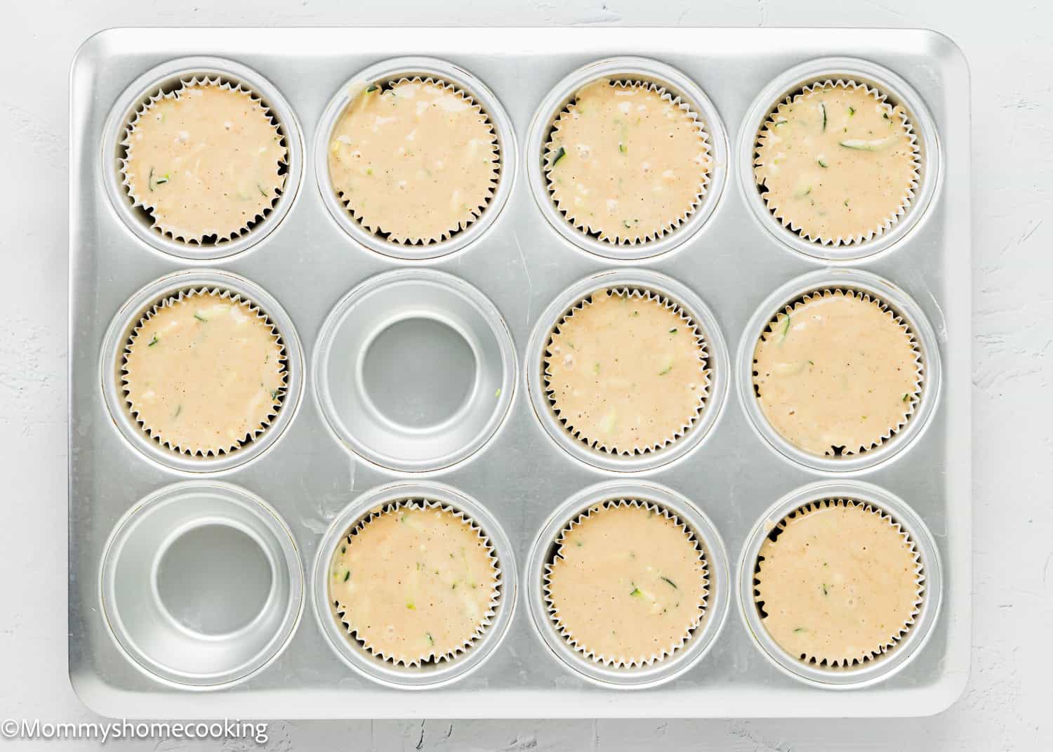 Simple Vegan Zucchini Muffins batter on a muffin tin.