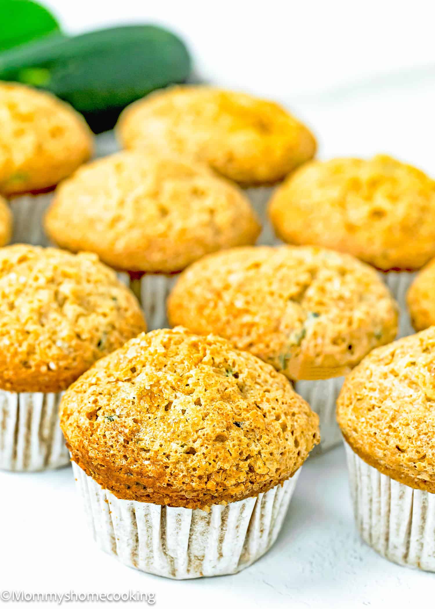 egg-free and dairy-free Zucchini Muffins over a white surface.