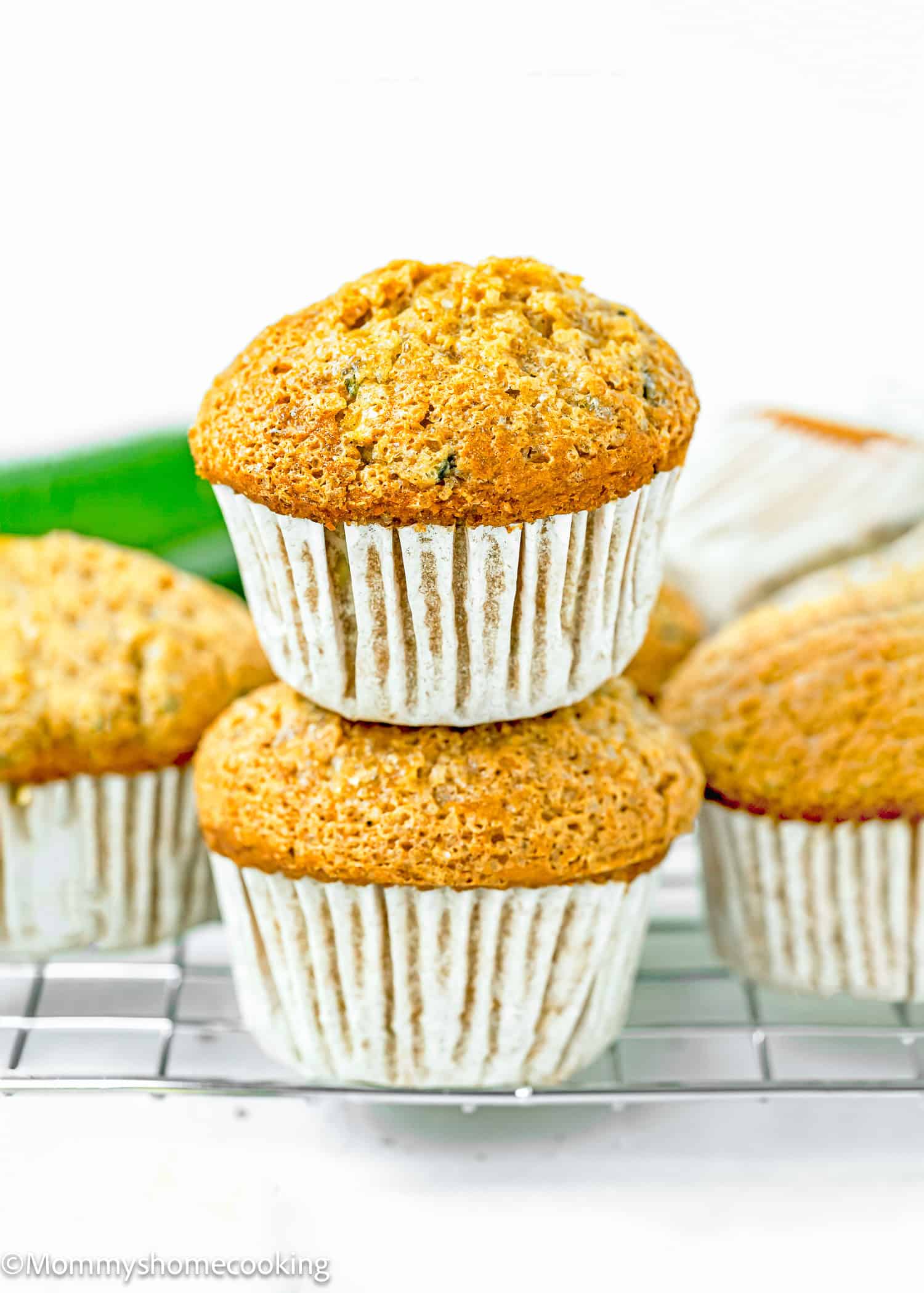 stack of two Simple Vegan Zucchini Muffins on a cooling rack.