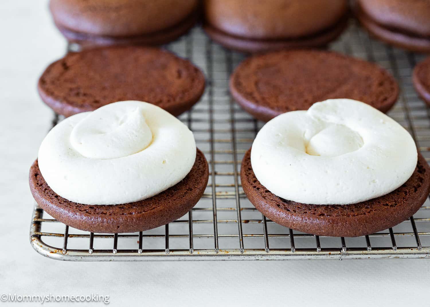 Egg-Free Chocolate Whoopie Pies with frosting on a cooling rack.