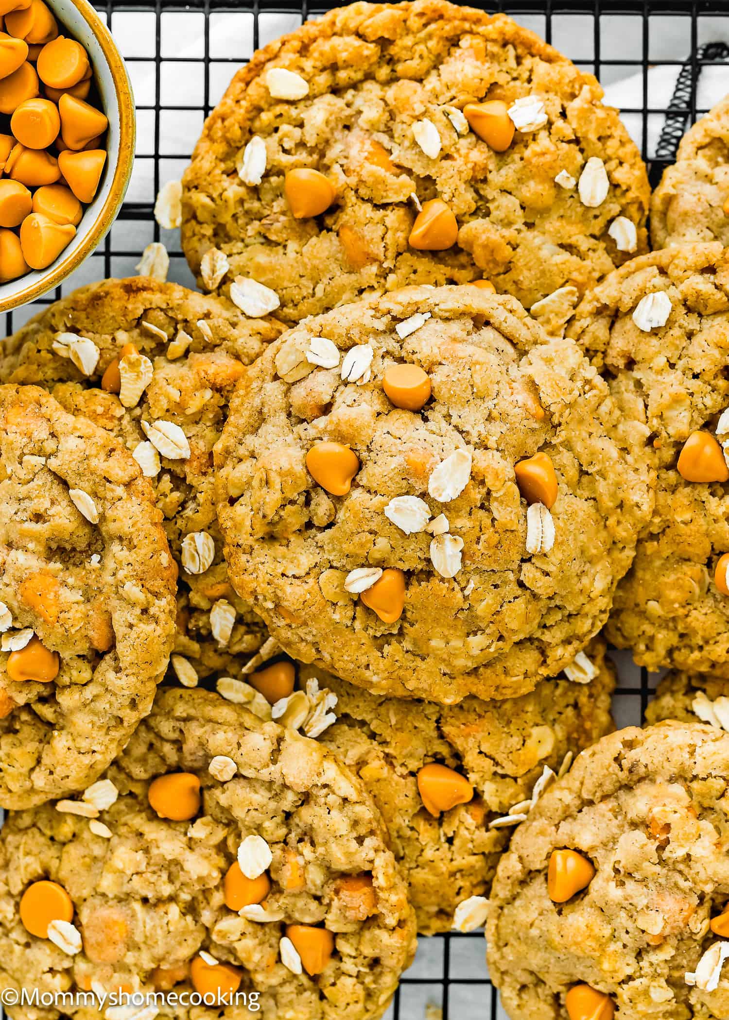 Eggless Easy Oatmeal Scotchies Cookies over a cooling rack with a bowl with butterscotch chips on the side.