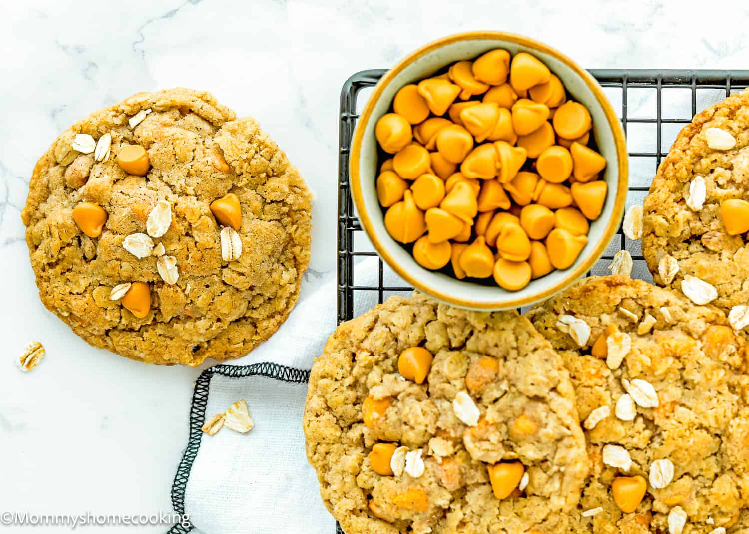 Egg-free Easy Oatmeal Scotchies Cookies over a cooling rack with a bowl with butterscotch chips on the side.