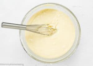 Easy Peach Muffins batter in a bowl with a whisk.