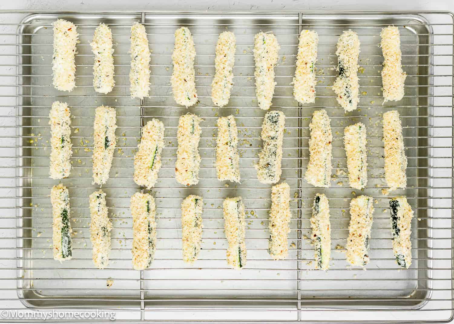 unbaked Eggless Zucchini Fries over a cooling rack on a baking sheet.
