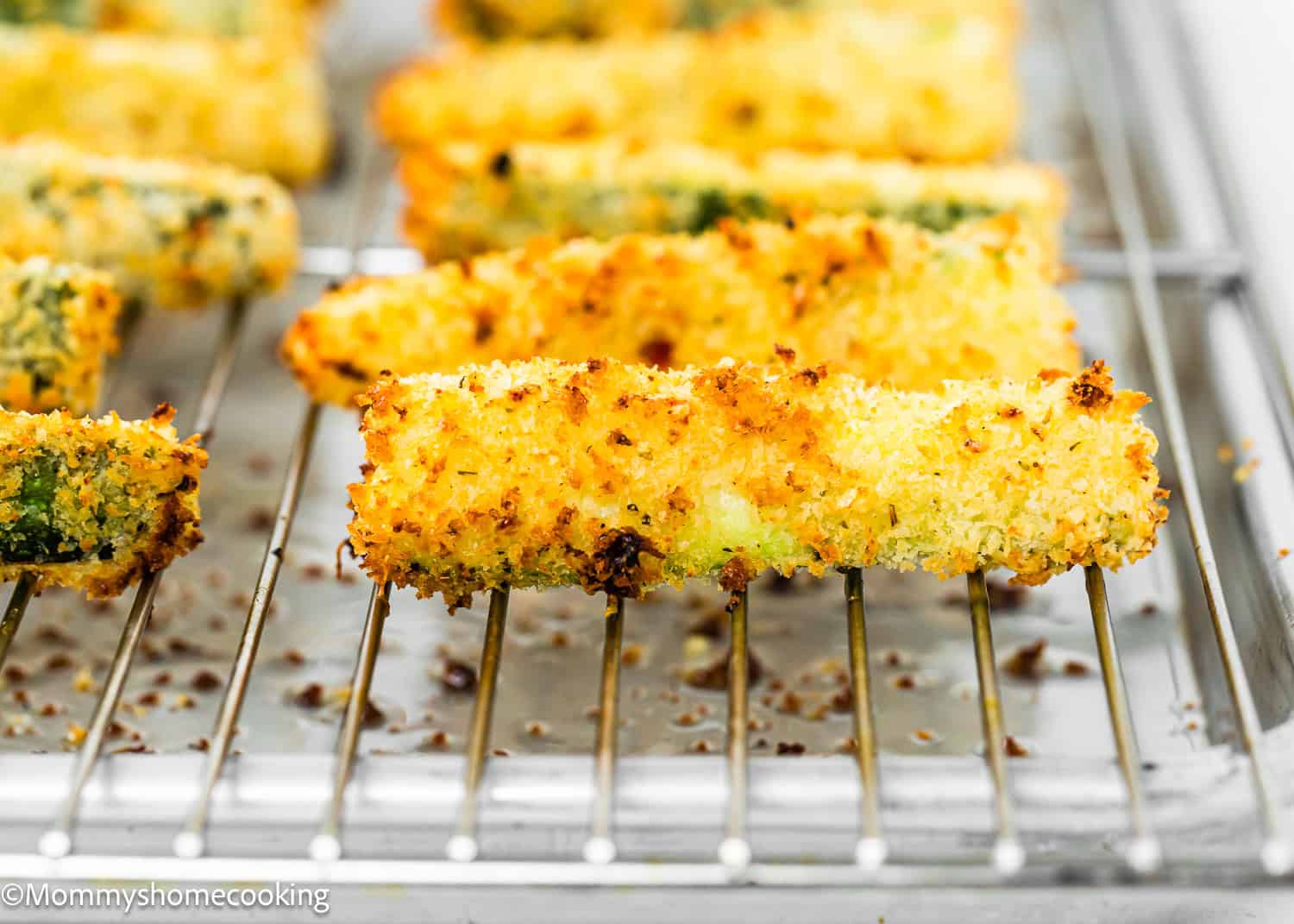 baked Egg-free Zucchini Fries over a cooling rack on a baking sheet.