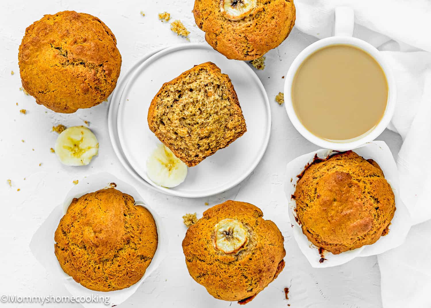 Healthy Easy Banana Muffins over a white surface with a cup of coffee on the side.