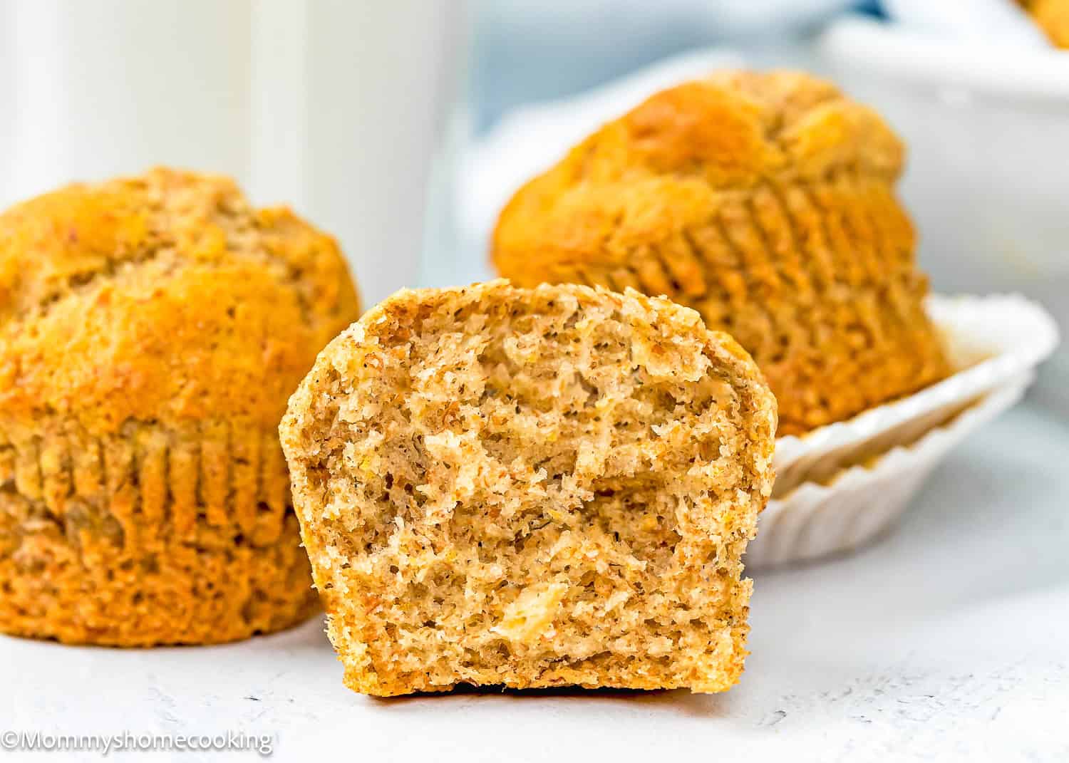 a Healthy Egg-Free Mini Banana Muffin over a white surface cut in half showing its perfect texture.