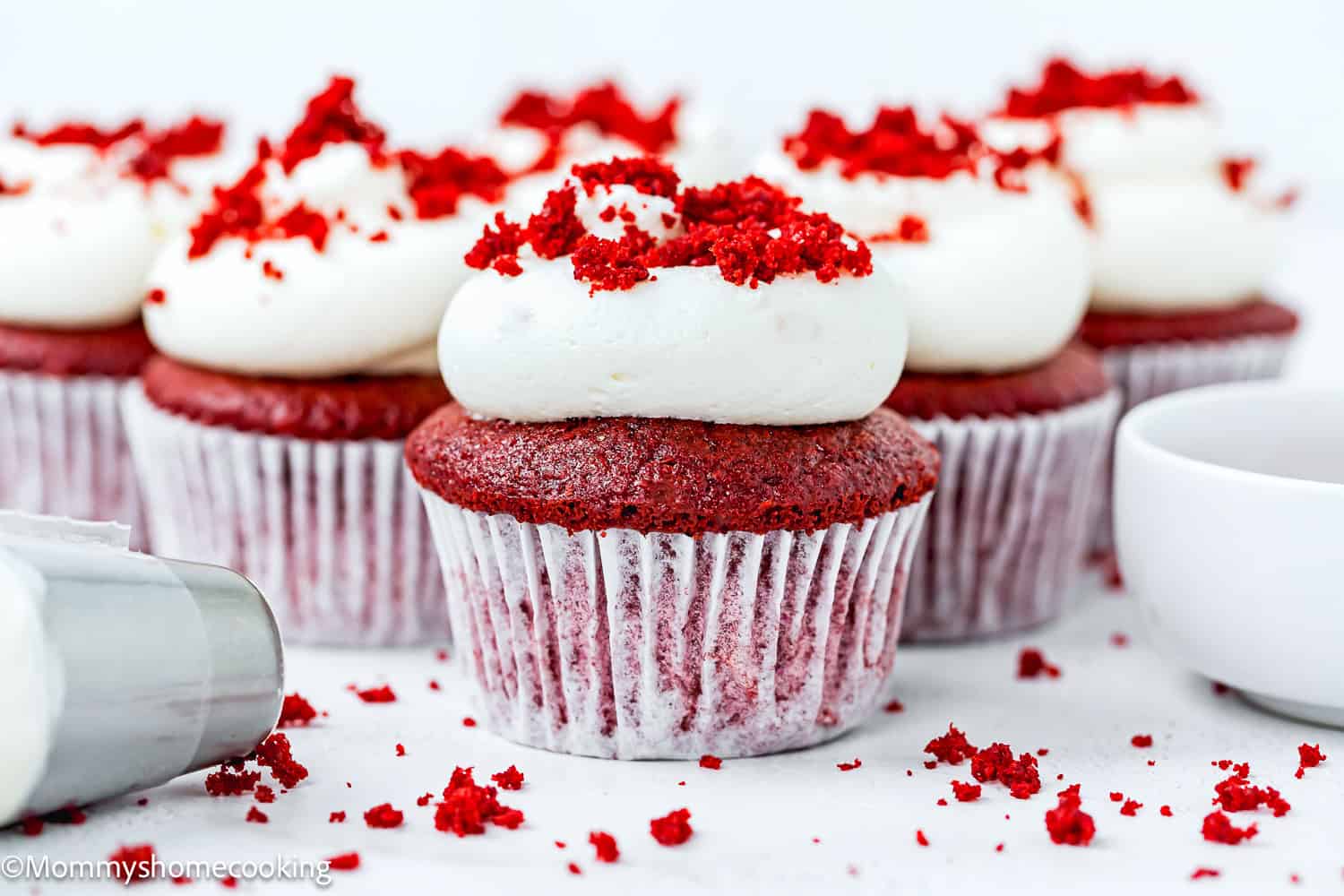Vegan Red Velvet Cupcakes with frosting and red velvet crumbs on top.