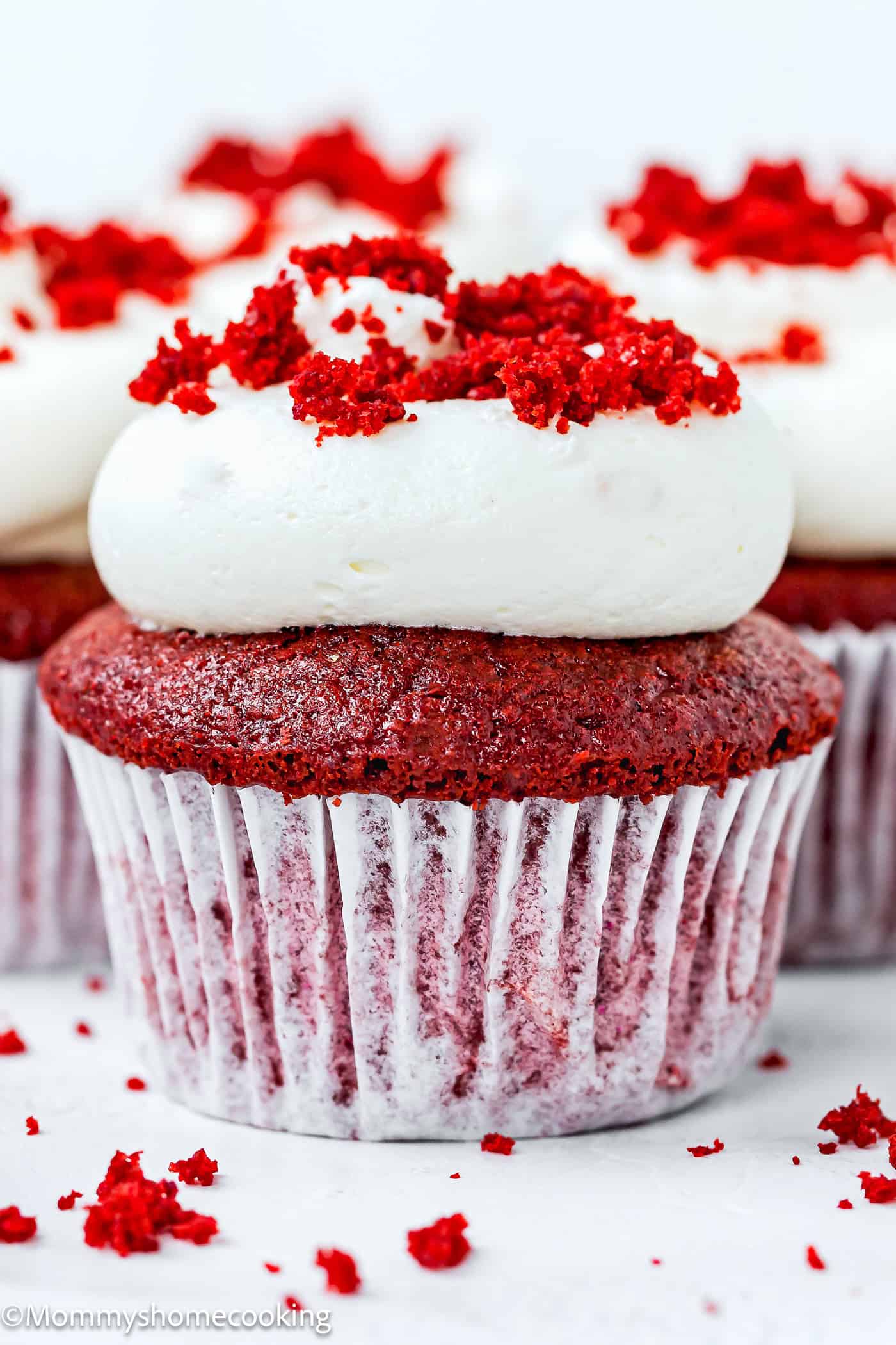 Vegan Red Velvet Cupcake with frosting and red velvet crumbs on top.