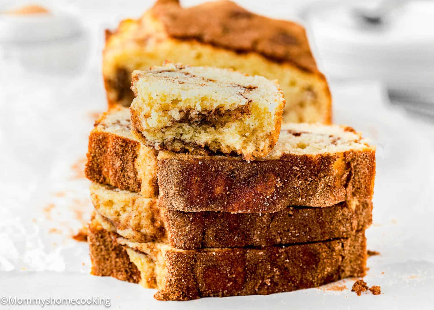 stack of 4 sliced of Cinnamon Swirl Quick Bread made with no eggs and no dairy, sliced showing its perfect inside texture over a white surface.
