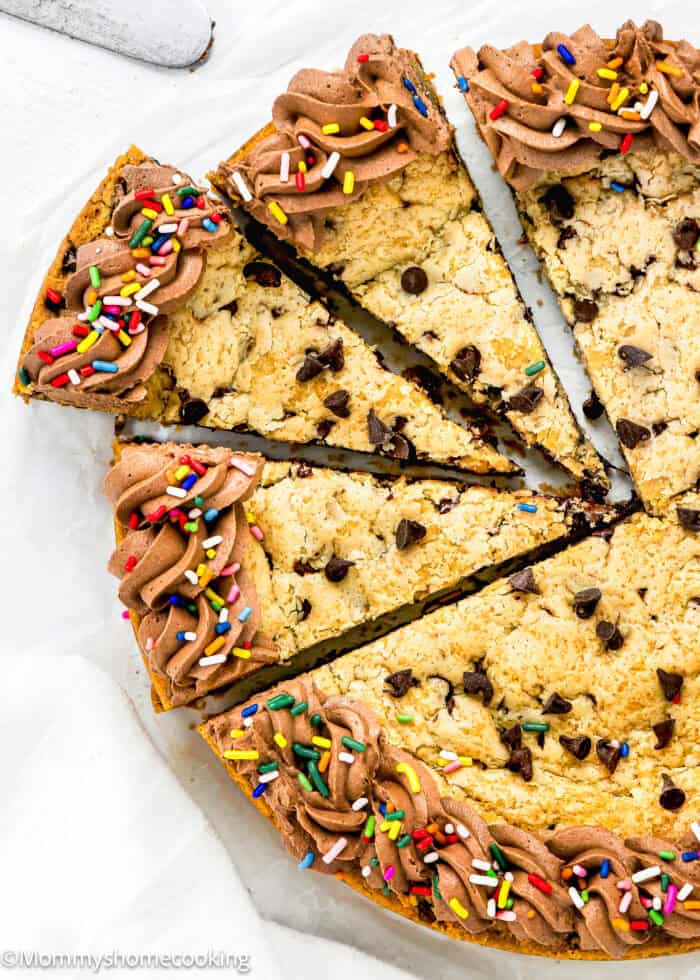 a sliced Eggless Chocolate Chip Cookie Cake over a white surface.