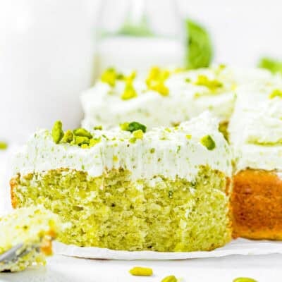 slice of Egg-Free Easy Pistachio Cake showing its perfect fluffy inside texture over a piece of parchment paper.