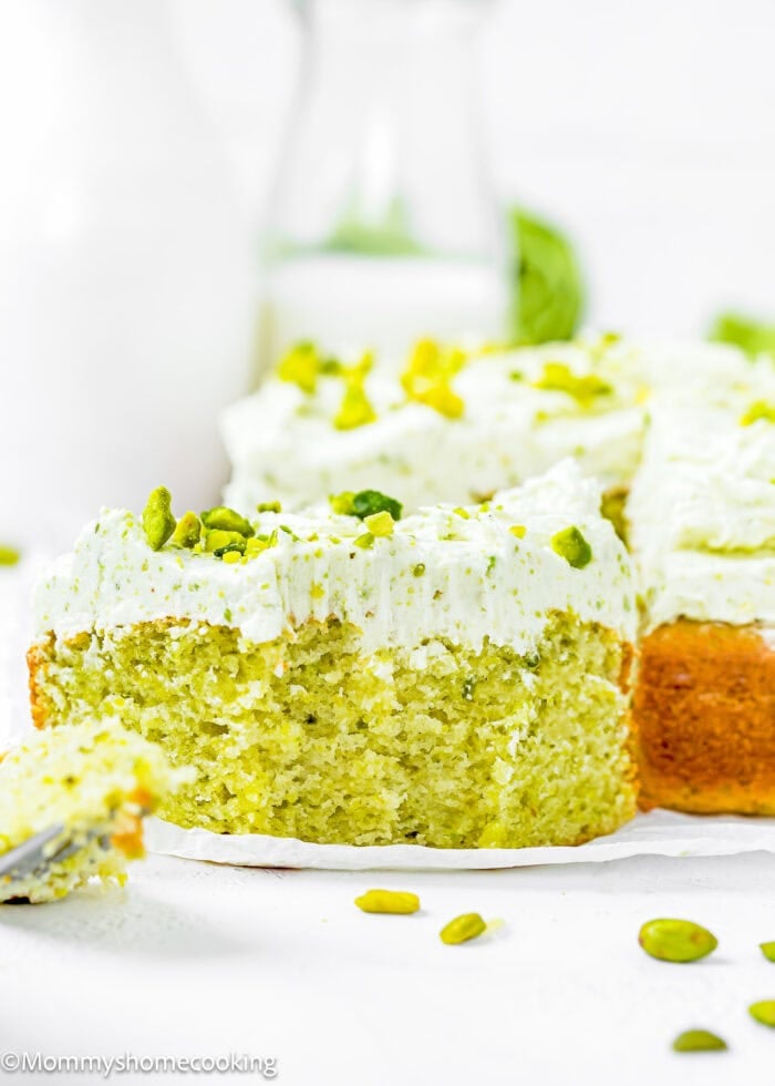slice of Egg-Free Easy Pistachio Cake showing its perfect fluffy inside texture over a piece of parchment paper.