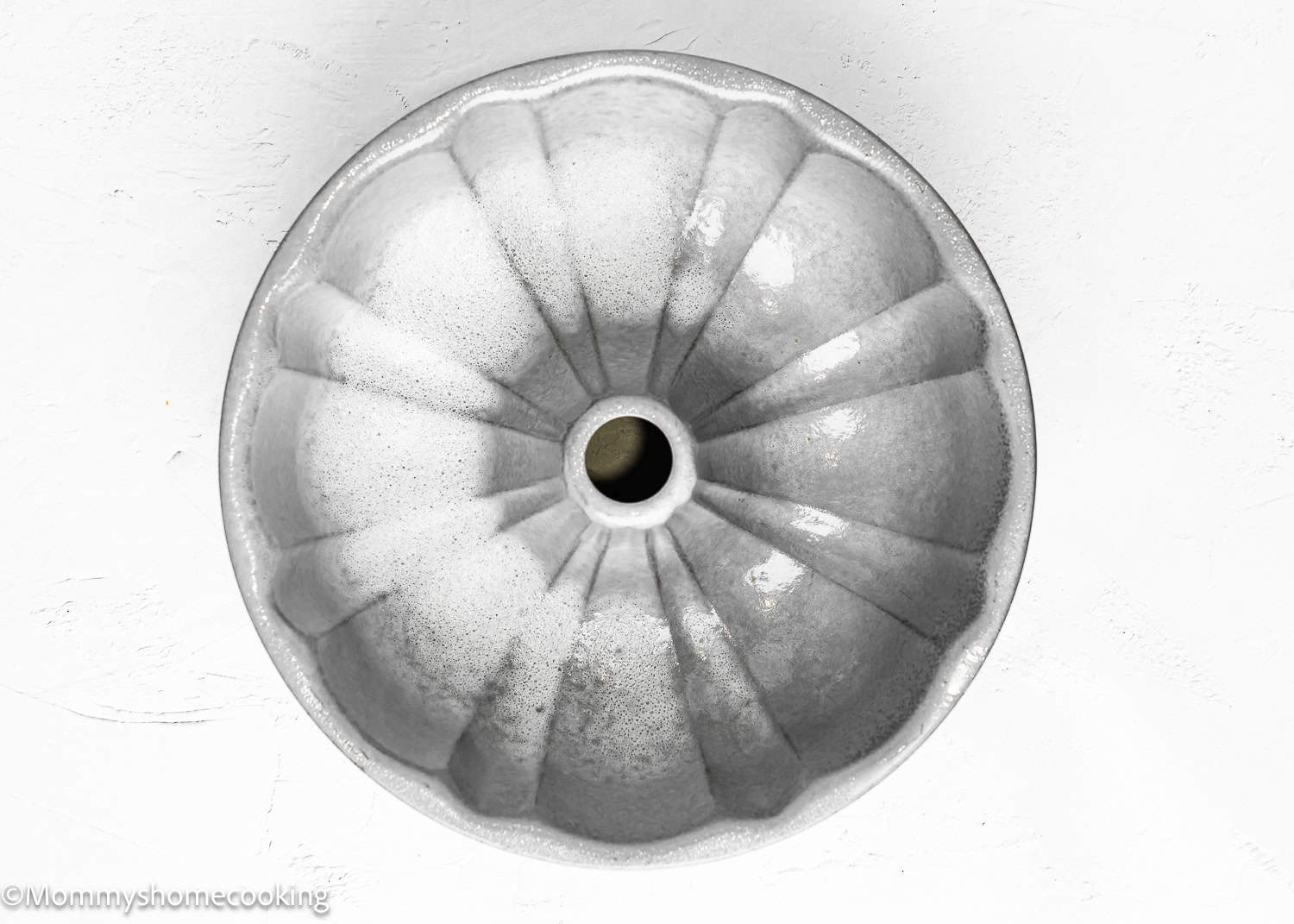 greased bundt cake pan on a white surface.