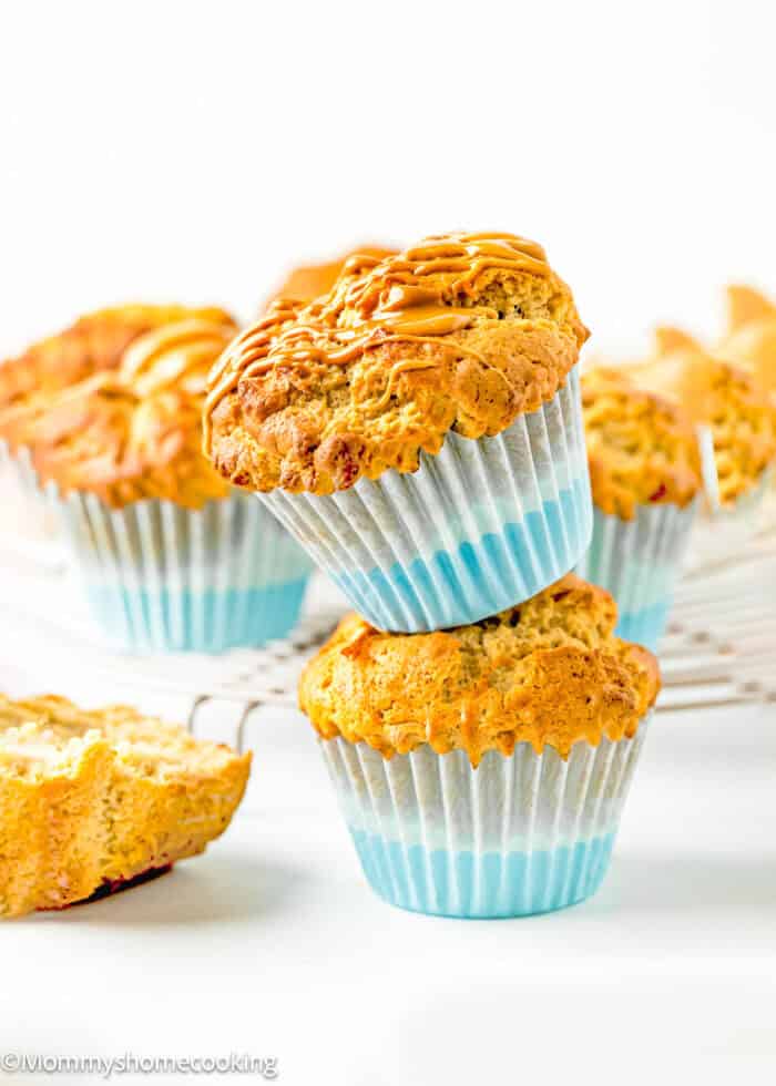 two Easy Vegan Banana Peanut Butter Muffins over a white surface with more muffins in the background.