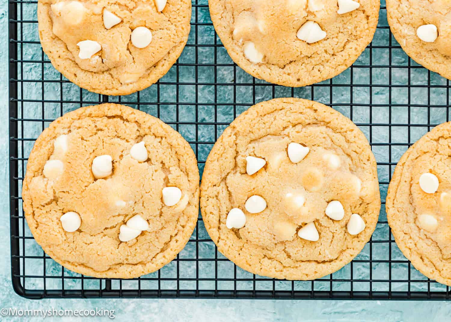 baked Eggless White Chocolate Cookies over a cooling rack.