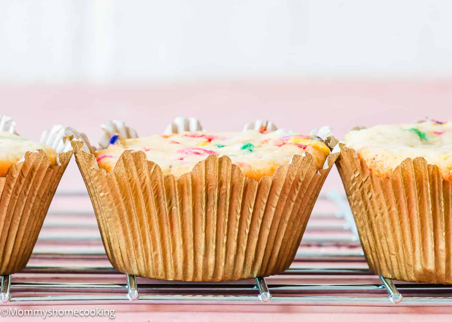 three nor properly risen cupcakes over a cooling rack. 