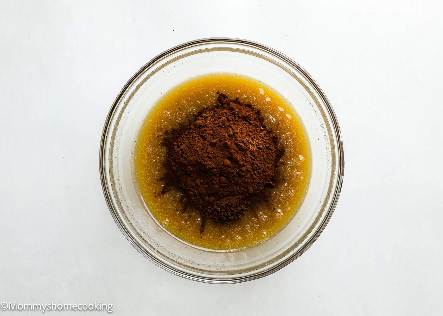 wet ingredients mix together in a bowl with cocoa on top to make brownies. 