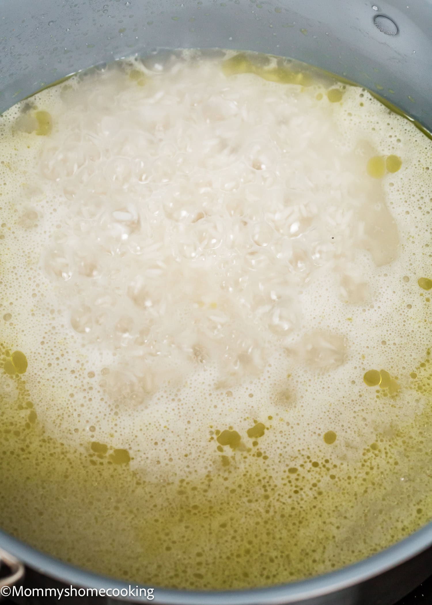A pot of rice boiling in water, with foam and bubbles forming on the surface—just one of the steps in How To Cook Fluffy Rice On Stove (Beginner-Friendly Guide!).