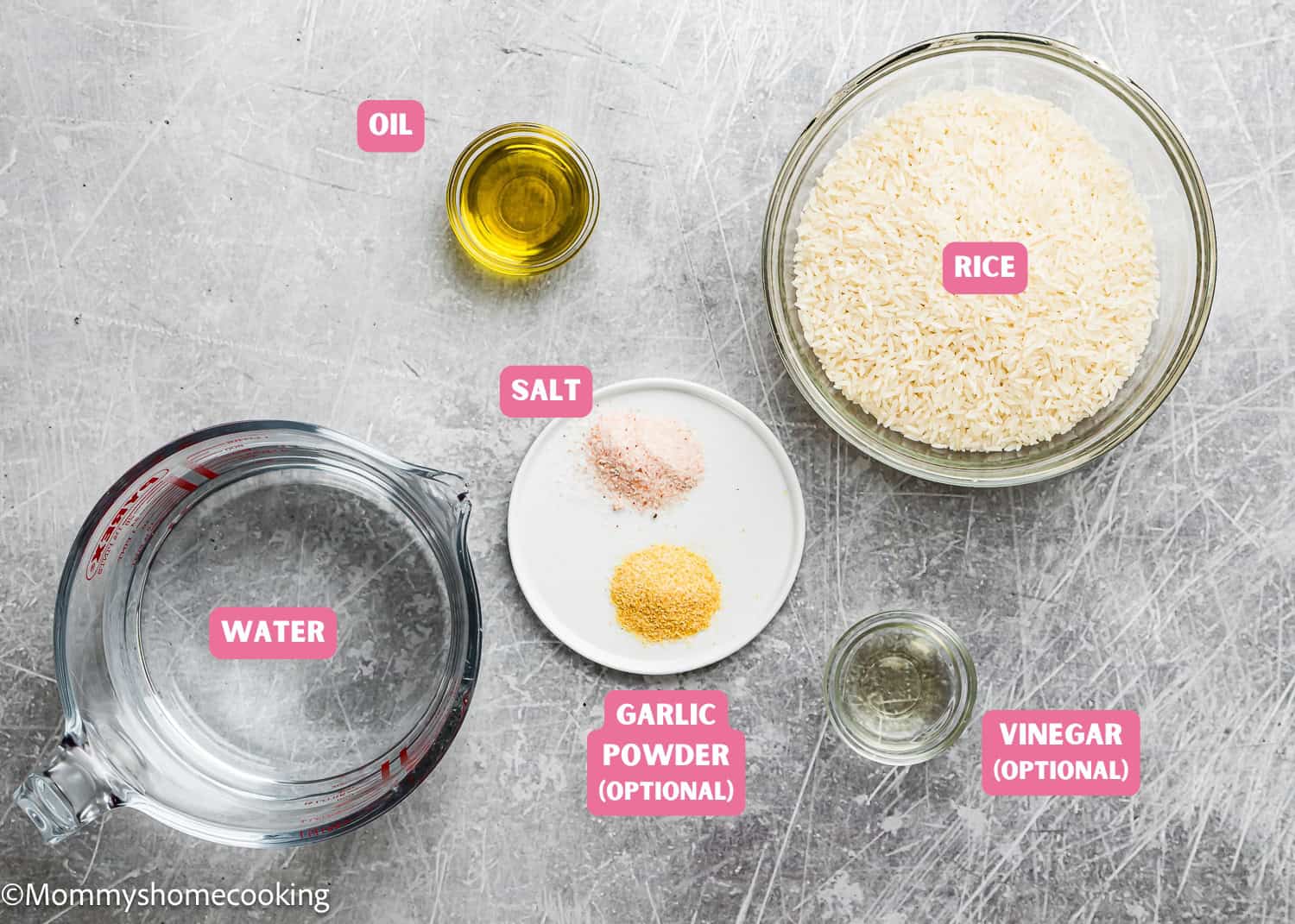 Top-down view of labeled ingredients in bowls and containers: oil, uncooked rice, water, salt, optional garlic powder, and vinegar on a gray surface—perfect for How To Cook Fluffy Rice On Stove (Beginner-Friendly Guide!).