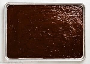 A baking sheet filled with an even layer of Eggless Texas Sheet Cake batter, ready to be baked.