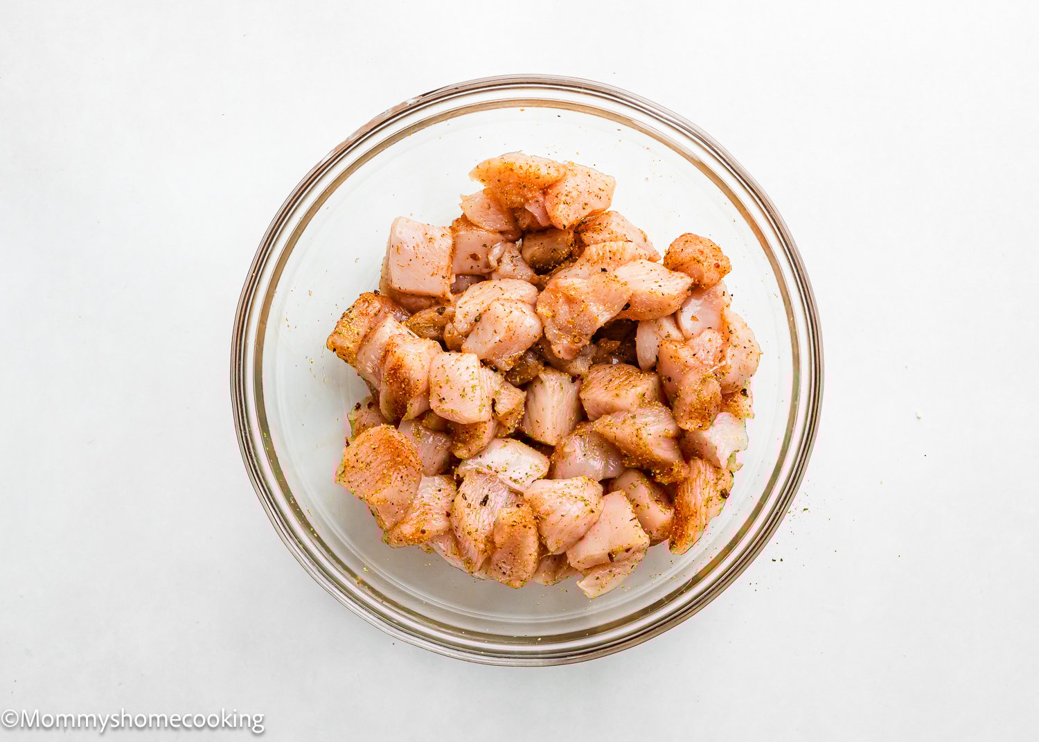 chicken breast cut into bite size pieces, seasoned in a bowl. 
