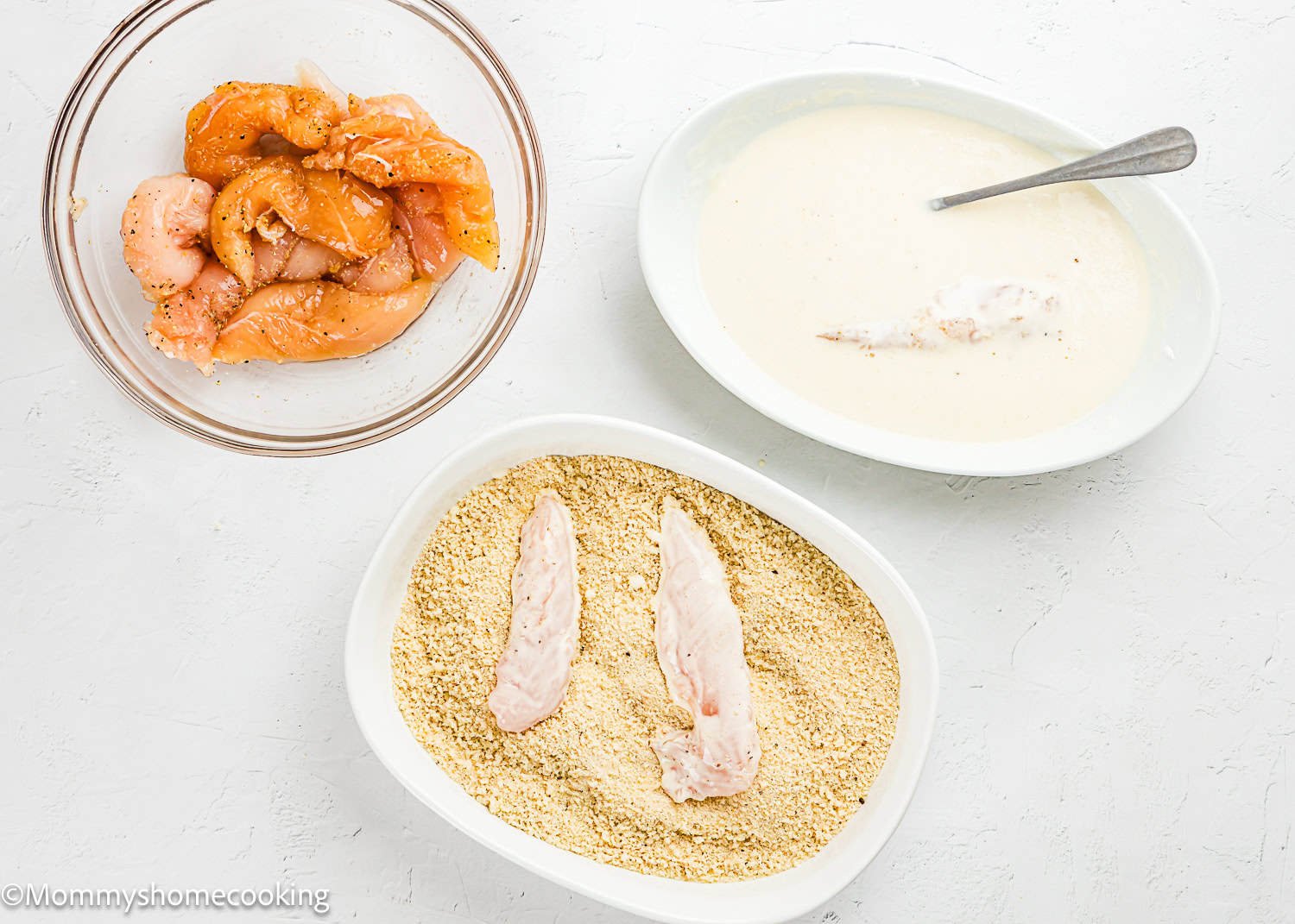 Three bowls show steps for Easy Air Fryer Chicken Tender (No Eggs - No Dairy): marinated chicken strips, batter-coated chicken, and pieces being dredged in breadcrumbs.