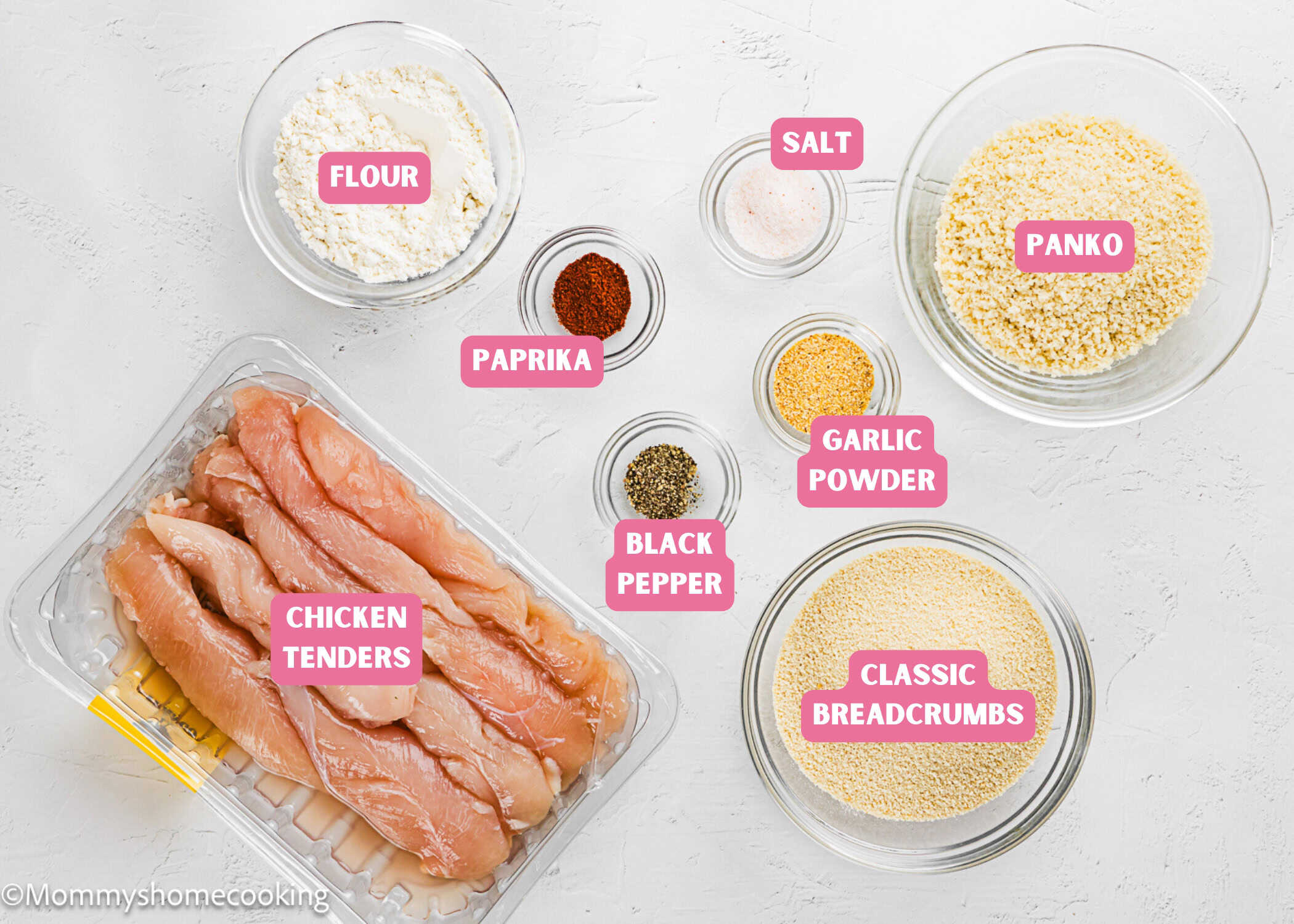 Raw chicken tenders, flour, paprika, black pepper, salt, garlic powder, panko breadcrumbs, and classic breadcrumbs arranged on a white surface for an Easy Air Fryer Chicken Tender (No Eggs - No Dairy) recipe.