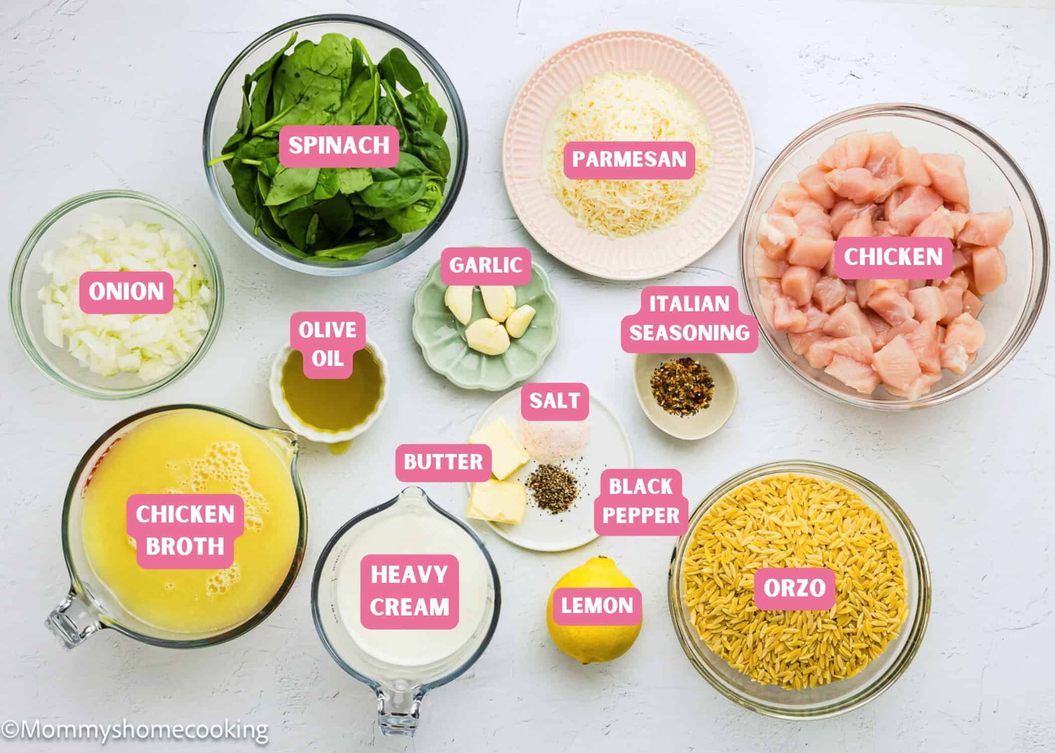A top view of labeled ingredients in bowls for an Easy Lemon Chicken Orzo (One Pot) recipe, including chicken, orzo, spinach, onion, chicken broth, heavy cream, parmesan, garlic, butter, olive oil, lemon, and seasonings.