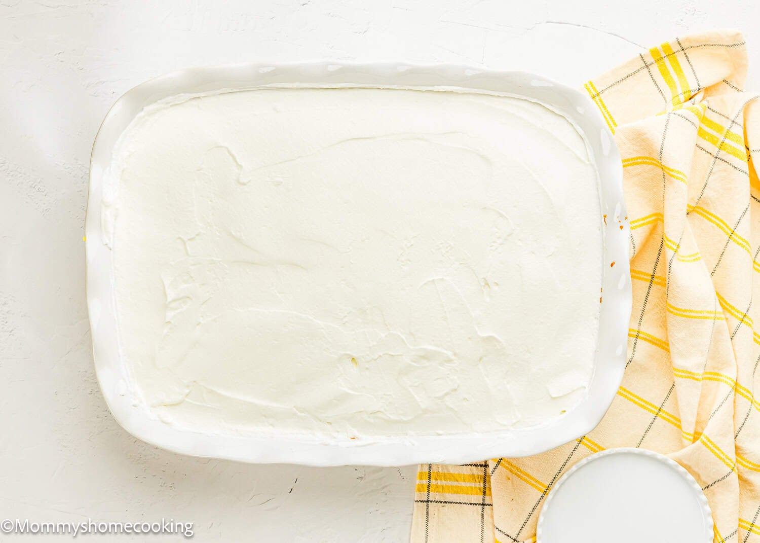 Eggless Lemon Poke Cake topped with whipped cream.