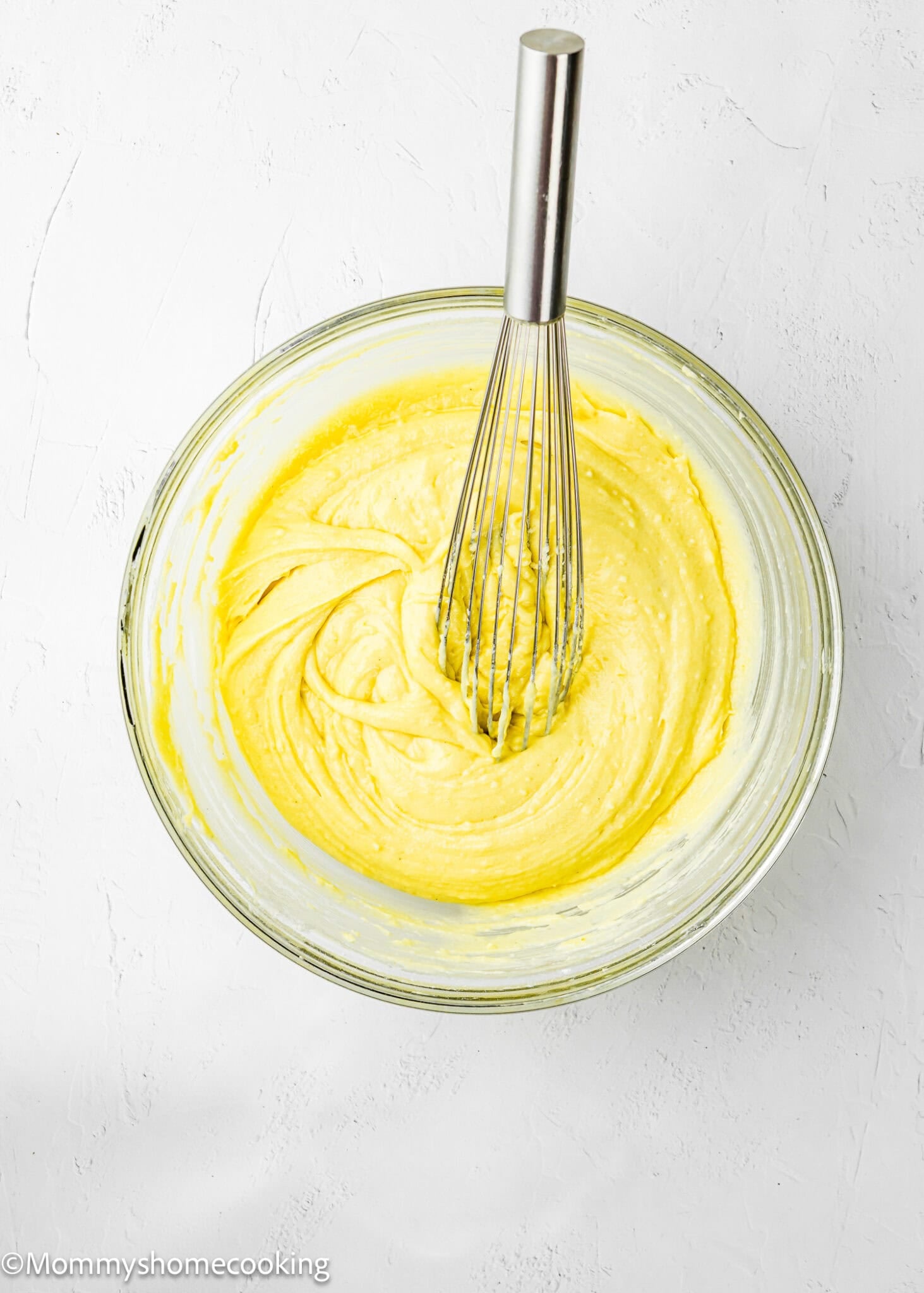 Eggless Lemon Poke Cake batter in a bowl with a whisk.