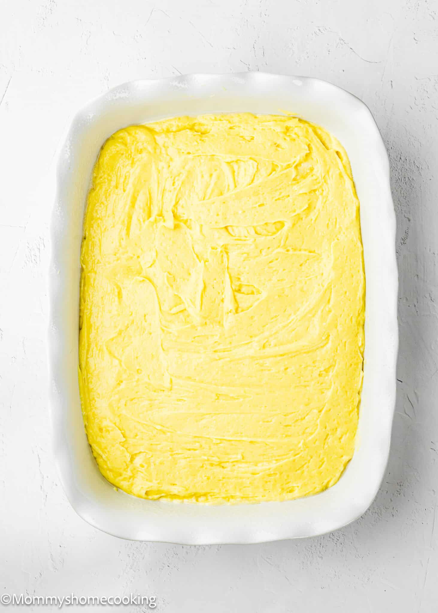 unbake Eggless Lemon Poke Cake in a rectangular baking dish.
