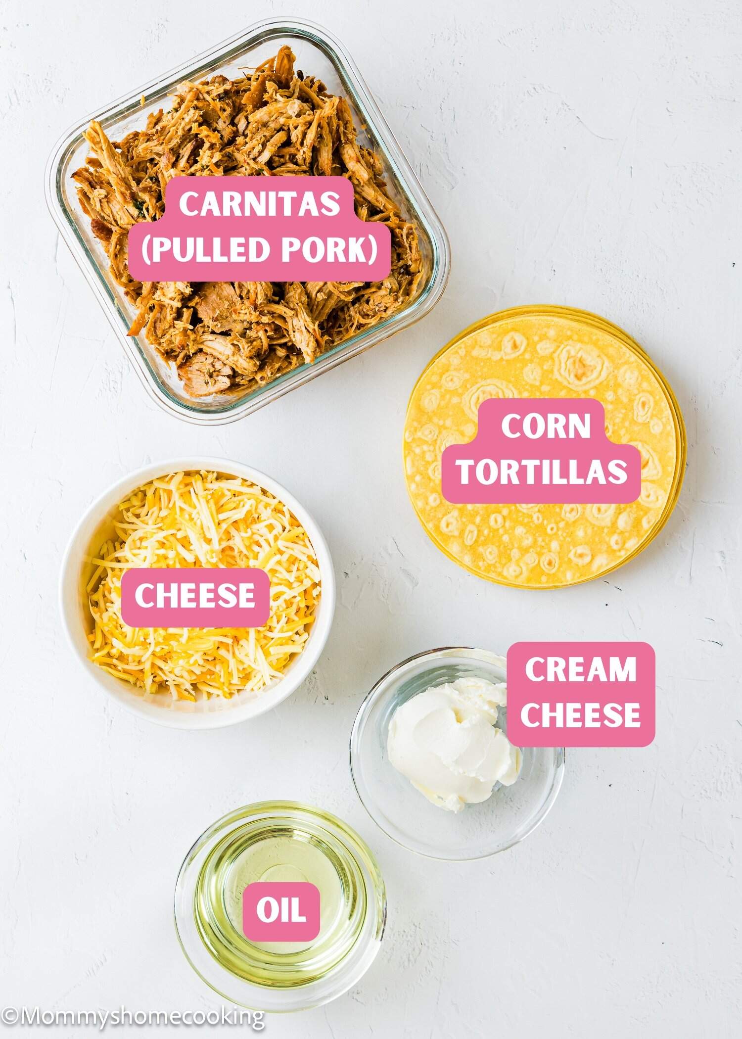 Five ingredients for making carnitas tacos are arranged on a white surface: pulled pork, a stack of corn tortillas, shredded cheese, a dollop of cream cheese, and a small bowl of oil, each labeled with pink text.