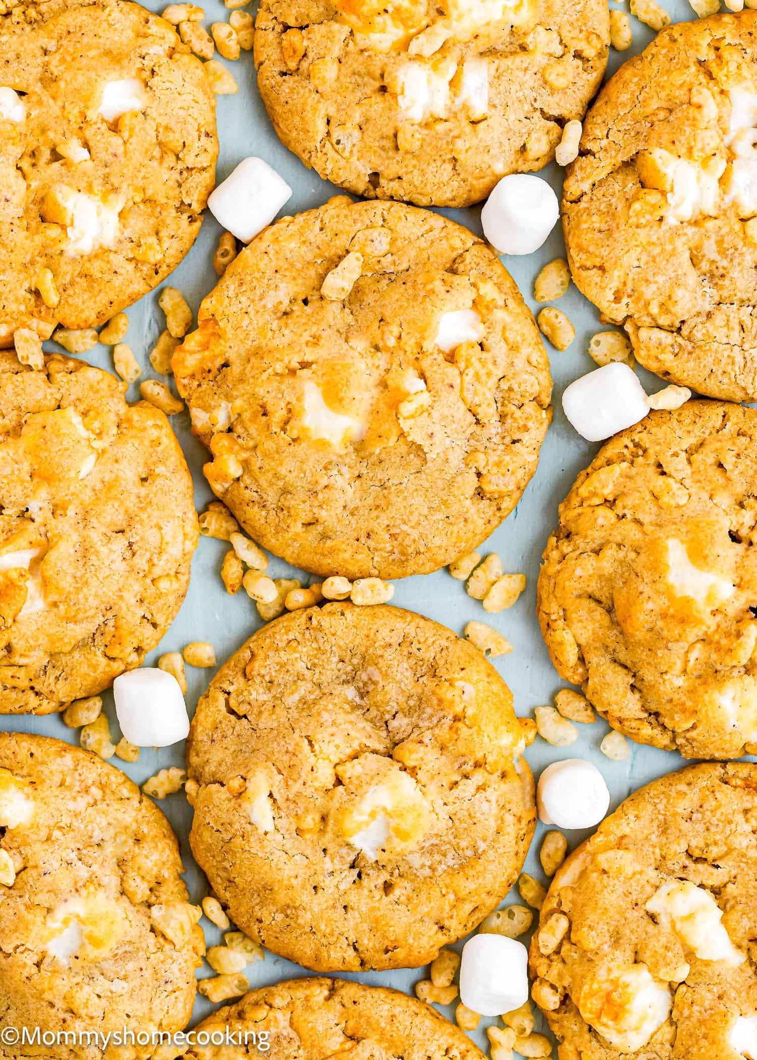 Rows of golden brown Easy Marshmallow Rice Crispy Cookies (Costco Copycat – Egg-Free), with visible white marshmallow pieces, plus mini marshmallows and crispy cereal sprinkled around them.
