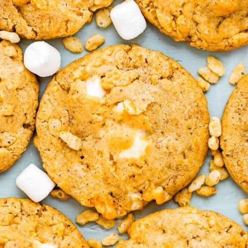 Close-up of Easy Marshmallow Rice Crispy Cookies (Costco Copycat – Egg-Free) with visible marshmallows and crispy rice cereal pieces scattered on a light surface.