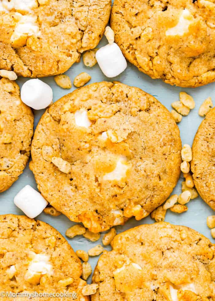 Close-up of Easy Marshmallow Rice Crispy Cookies (Costco Copycat – Egg-Free) with visible marshmallows and crispy rice cereal pieces scattered on a light surface.